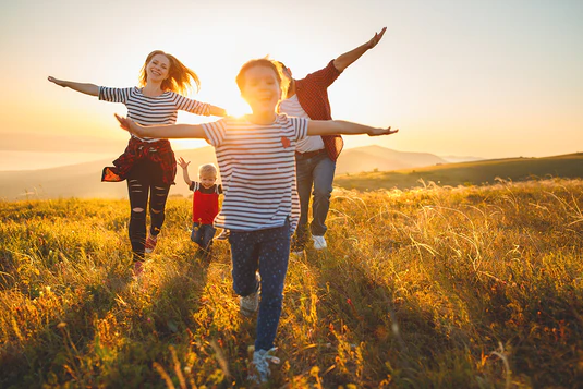 Image of a family running in a hill at sunset